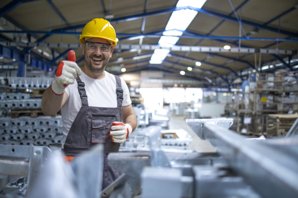 Homem em industria fazendo sinal de positivo