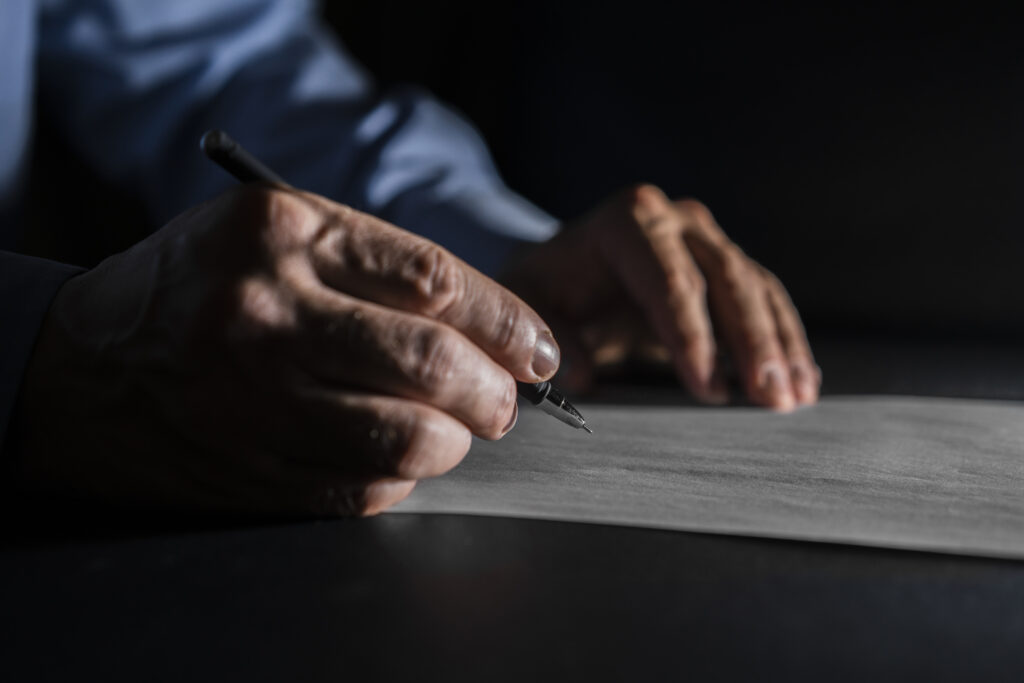Mão de um homem escrevendo em um papel